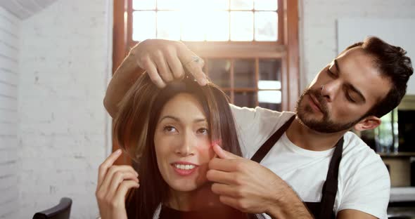 Male hairdresser styling a womans hair alt