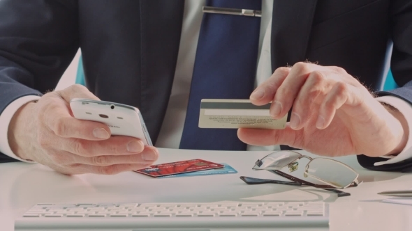 Male Hands Holding Credit Card When Paying Mobile Phone