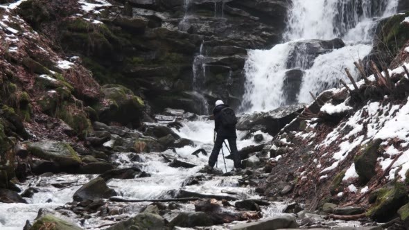 Photographer Making Photo of Winter Waterfalls in