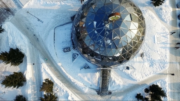 Flying Over The Small City Park In Winter. Round Building. Spherical Building