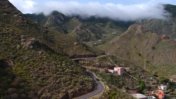 Winding mountain roads and majestic valley of Tenerife island, aerial descend view alt