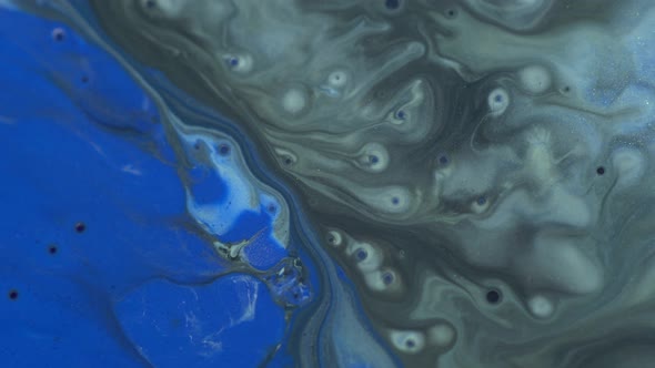 Blue, black, silver colors oil paint pouring close up. Fluid Art painting. Paint movement macro alt