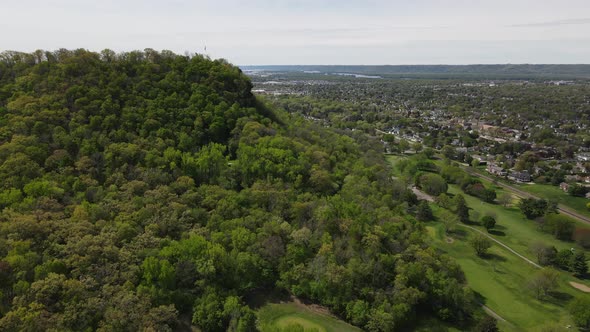 Picturesque aerial view around mountain of city sprawling in valley between mountains and river.