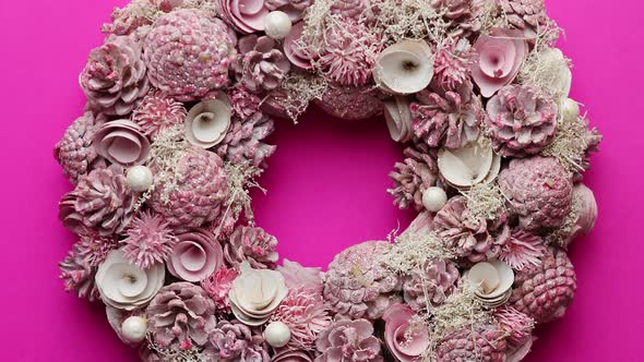 Christmas Wreath Made with Flowers, Pines and Leafs Isolated on Pink Background alt
