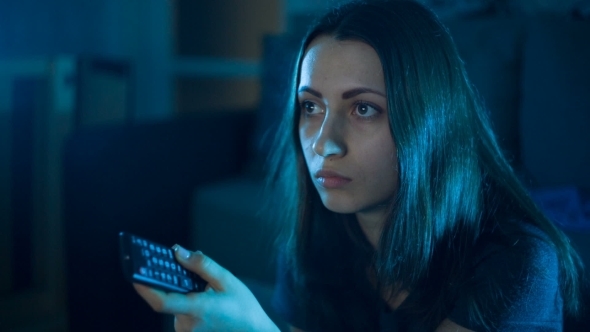 Woman With TV Remote Switcing Boring TV Channels alt