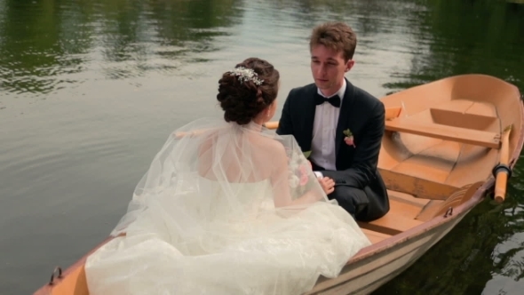 Lovely Bride And Groom Talk And Hold Hands On The Romantic Canoe Trip. Paris Honeymoon