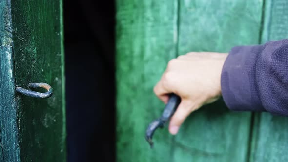 Closeup Caucasian Man is Opening a Wooden Door in a House Locked on a Hook