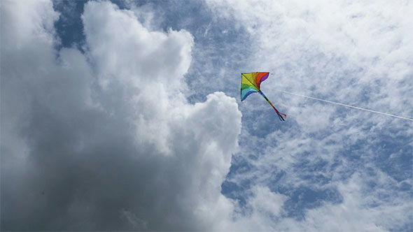 Childrens Kite Flying against Dramatic Clouds