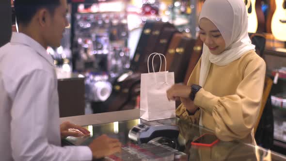 Asian Muslim Woman Using smartwatch For Payment 03