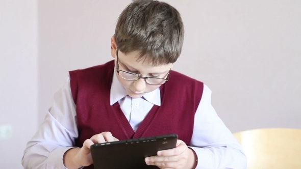 Boy With Glasses Playing The Tablet At School alt