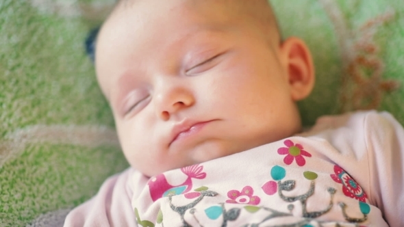 Precious Newborn Baby Is Laying On a Comfortable Bed, Sleeping Peacefully