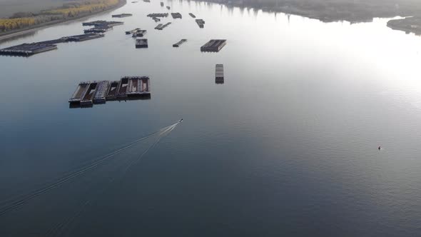 Boats Traveling On Danube River With A View Of Vast Forest At The Riverside. aerial alt