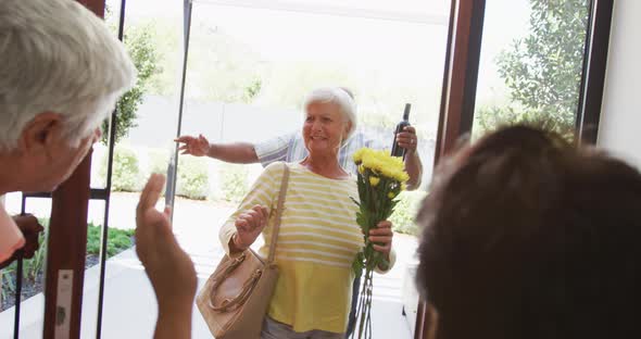 Happy senior biracial couple opening door at retirement home alt