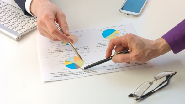 Male Hands Pointing At Paper Containing Data About Economic Situation