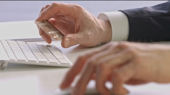 Male Hands Holding Credit Card And Using Mouse