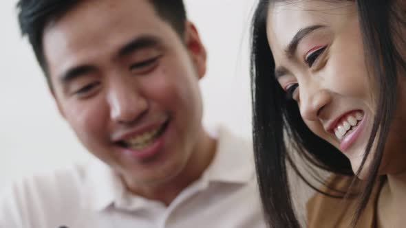 Asian couple using smartphone browsing social media.