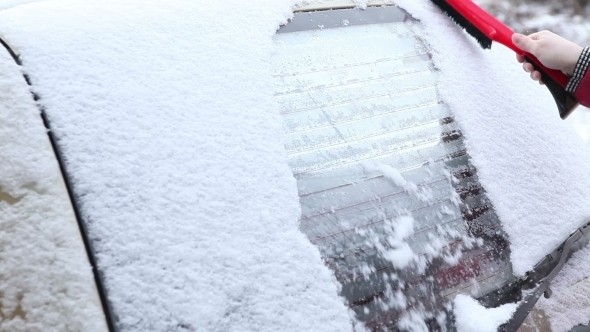 Woman To Clear Snow From The Car Window alt