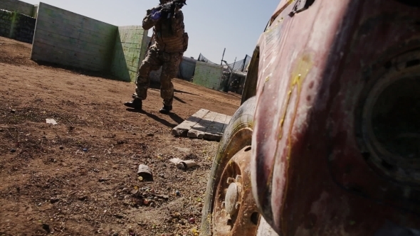 Paintballer With Automatic Rifle Moves Into Position alt