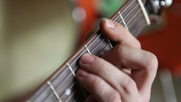 Man Plays Guitar, His Fingers On The Fretboard  alt