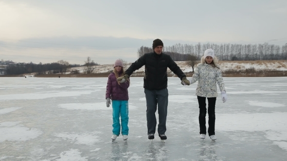 Father With Daughters Ice Skating On Frozen Lake alt