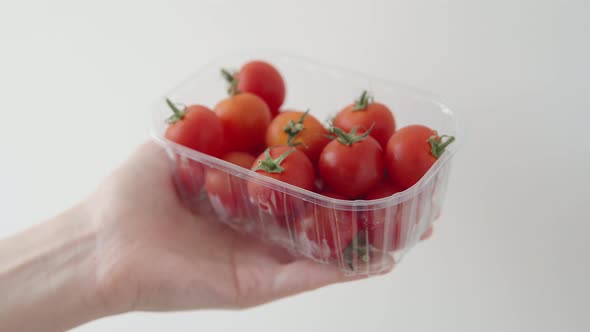 Woman Shows Ripe Red Cherry Tomatoes Grown on a Plantation for Sale Closeup in Box