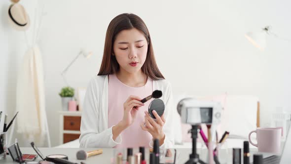 Young beautiful Asian woman professional beauty vlogger influencer recording make up tutorial video