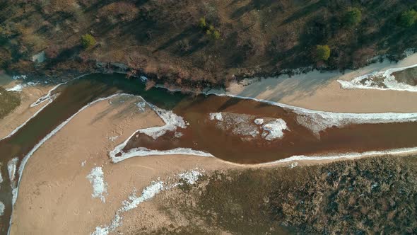 Aerial Drone Footage of Flight Over a Small River in Winter Topdown View alt