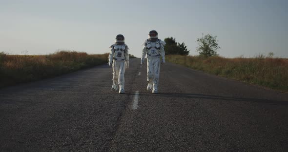 Two Astronauts Walking on Road alt