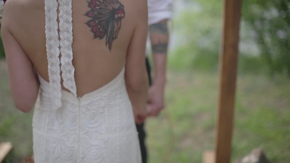 Couple With Tattoos Holding Hands In a Forest