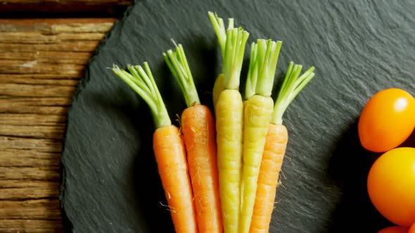 Tomatoes and carrots arranged on wooden table 4k alt