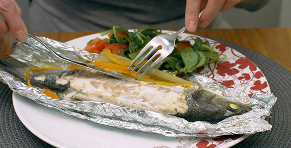 Woman Eating Grilled Fish