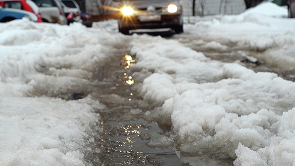 Car Approaching Along a Slushy Road