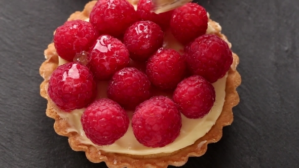 Unfinished To Eat Tartlet With Custard And Fresh Ripe Raspberries And Brush For Glazing Over Gray
