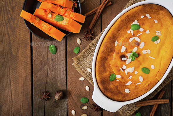 Cottage cheese and pumpkin pudding with cinnamon and nutmeg on wooden background. Top view