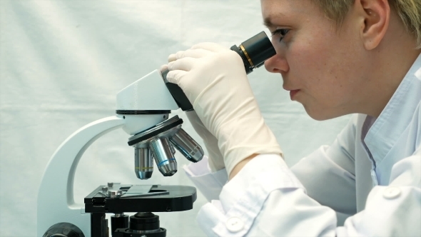 Female Doctor Scientist Looking Through Microscope
