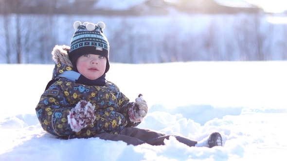 Little Boy In a Winter Cap Playing In The Snow