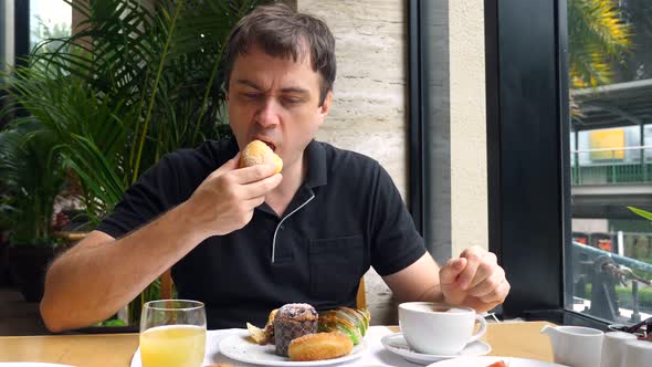 Unhappy Angry Young Man Eats Fresh Baked Goods and Does Not Enjoy His Food alt