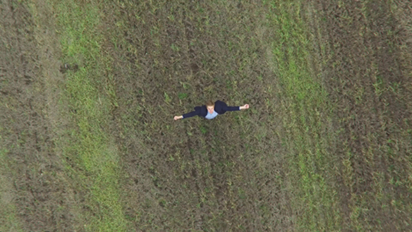 Man In The Field Raises His Hands Up