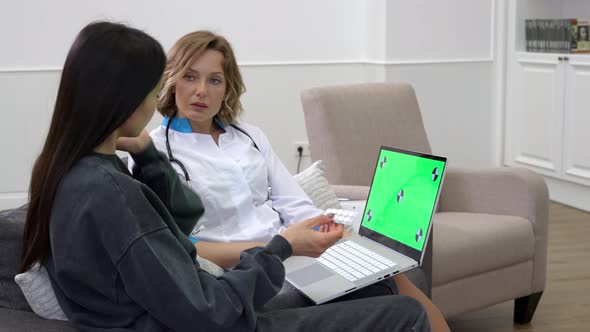 Female Doctor Using Laptop During Medical Consultation at Patient Home alt