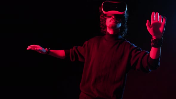 Man with VR Helmet on His Head Playing in Redblue Lights Online Party alt
