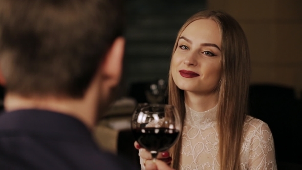 Young Happy Couple On Romantic Date Drinking Glass Of Red Wine 
