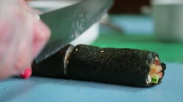 Sushi Master Cuts Finished Rolls