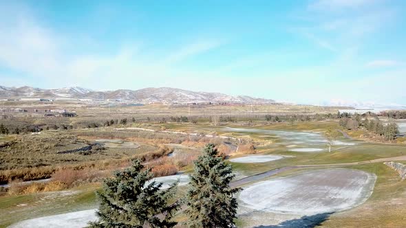 Parallax shot of a golf course in winter with a light dusting of snow - zooming in during retreating alt