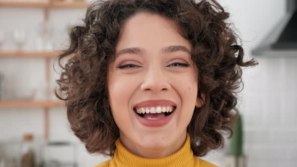 Close Up Face Smiling Hispanic Curly Woman Looking Camera at Home Kitchen alt