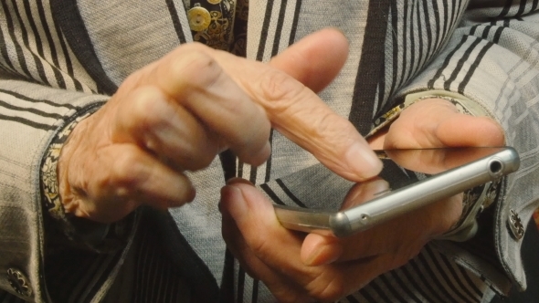 Hands Of The Old Woman And Smartphone. 