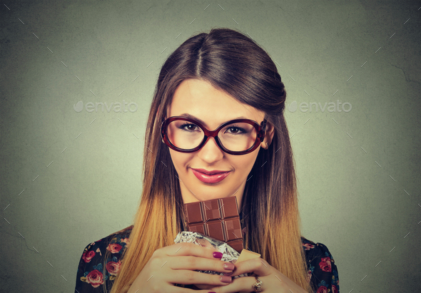 slim woman in glasses tired of diet restrictions craving sweets dark chocolate