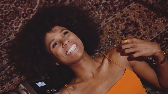 Woman With Afro Hair Smiling With Vintage 8Mm Camera alt