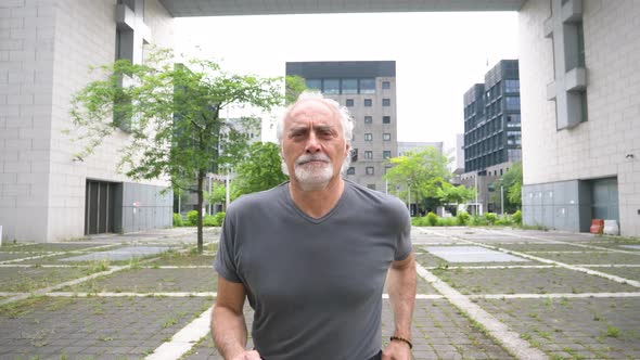 Slow motion shot of senior man jogging in city alt