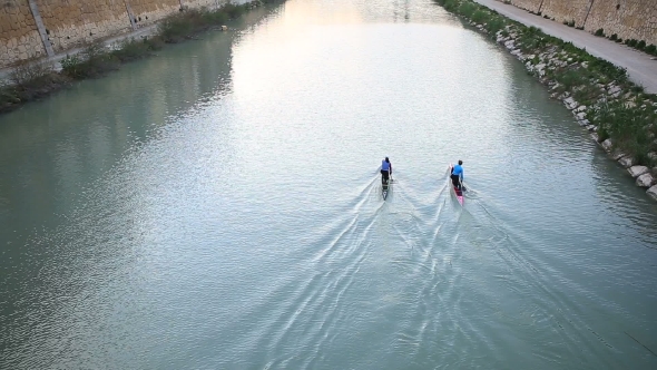 Paddling Two Boats In a River