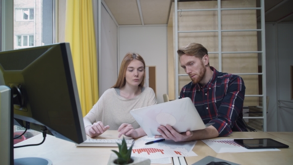 A Bearded Man With a Laptop Showing The Employee Data That She Enters Into Computer alt